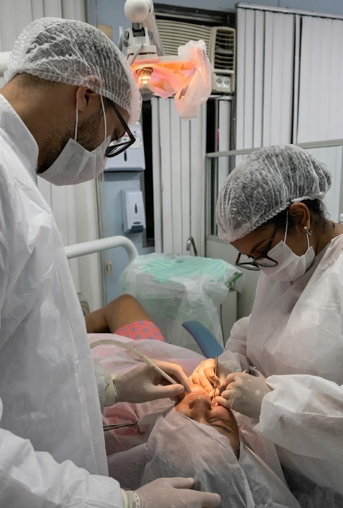 Dra. Karen Regina durante um atendimento no consultório, ao lado da equipe